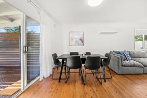 Poppi's Paradise - 5 Minutes Walk to the Beach في سانكشوري بوينت: غرفة طعام مع طاولة وكراسي وأريكة