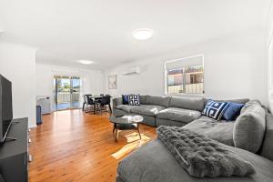 Poppi's Paradise - 5 Minutes Walk to the Beach في سانكشوري بوينت: غرفة معيشة بها أريكة وطاولة