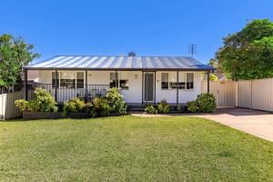 Poppi's Paradise - 5 Minutes Walk to the Beach في سانكشوري بوينت: بيت ابيض مع سياج وساحة