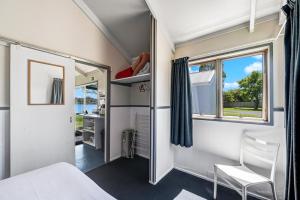 a small bedroom with a bed and a window at Waitangi Holiday Park in Paihia