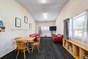 a living room with a table and chairs and a couch at Waitangi Holiday Park in Paihia