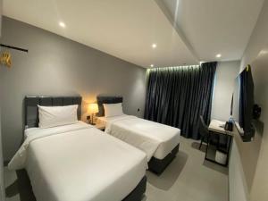 Una habitación de hotel con dos camas y un televisor. en MBS HOTEL Medan, en Medan 4 fotos más