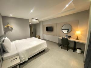a bedroom with a bed and a desk and a mirror at MBS HOTEL Medan in Medan