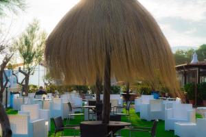 a restaurant with tables and chairs and a large umbrella at Holiday Village in Fondi
