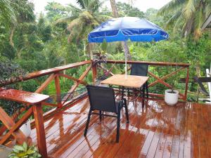 Master's Homestay في سوفا: سطح خشبي مع طاولة ومظلة