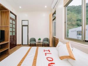 a bedroom with a bed and a large window at Brother Hotel & Travel in Cat Ba