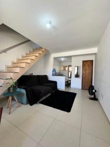 uma sala de estar com um sofá e uma escada em Duplex em Itaúna 4min da Praia que ocorre o WSL, 1min da pista de skate do LS, pracinha com parque infantil, quadra de futebol, tudo isso a 1 min da duplex, perto do comércio, wi-fi super rápido, monitoramento 24hrs em Saquarema mais 35 fotografias