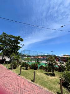 uma passarela de tijolos ao lado de um corpo de água em Duplex em Itaúna 4min da Praia que ocorre o WSL, 1min da pista de skate do LS, pracinha com parque infantil, quadra de futebol, tudo isso a 1 min da duplex, perto do comércio, wi-fi super rápido, monitoramento 24hrs em Saquarema