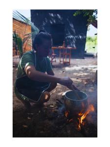 a young boy is cooking in a pot over a fire at Casa Segredo da Mata in Alter do Chao +19 photos