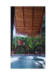 a bike parked under a straw roof at Casa Segredo da Mata in Alter do Chao