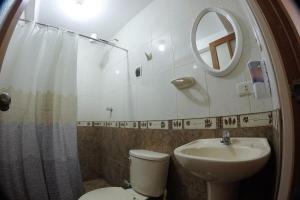 ein Badezimmer mit Toilette, Waschbecken und Spiegel in der Unterkunft Cozy & Centric Apartment in great location! in Cusco + 15 Fotos