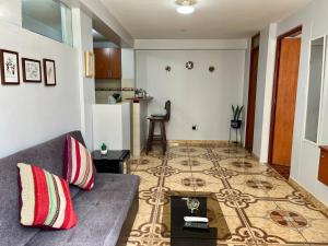 ein Wohnzimmer mit Sofa und Tisch in der Unterkunft Cozy & Centric Apartment in great location! in Cusco