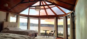 kantuta Lodge Uros في بونو: غرفة نوم بها نافذة كبيرة مطلة على الماء +10 صور