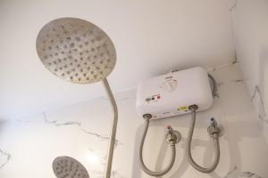 a shower head in a bathroom next to a shower at ARNOLD'S HOTEL in Pooc