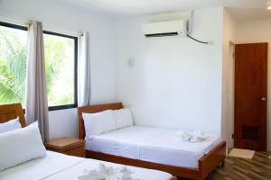 a room with two beds and a window at ARNOLD'S HOTEL in Pooc