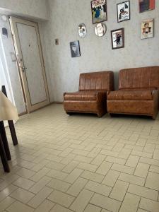 a living room with two brown leather couches and pictures on the wall at Luminoso depto céntrico para 4 personas 2 amb in Mar del Plata