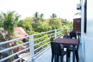 a balcony with a table and chairs and trees at ARNOLD'S HOTEL in Pooc