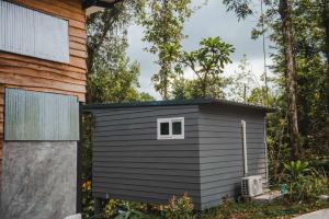 een klein zwart schuurtje naast een huis bij My Home Koh Kood1 in Ko Kood