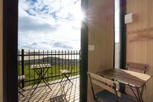 a balcony with a bench and a view of a field at Black Horse Cabin 4 by Tiny Away in Waitoki