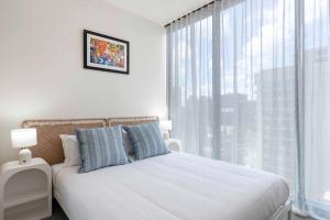 En eller flere senge i et værelse på Cloudline City Stay Victoria Tower CBD