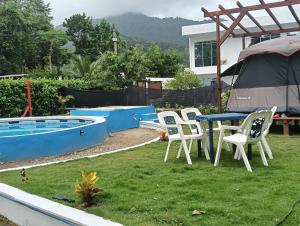 un cortile con tavolo, sedie e piscina di none a Capurganá Altre 4 foto