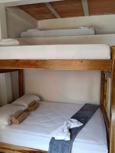 tre letti a castello in una piccola stanza con una cravatta di none a Capurganá