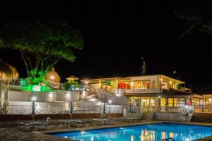 a large building with a swimming pool at night at Holiday Village in Fondi