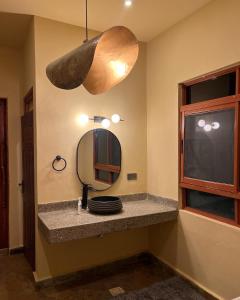 Vota Ranch Luxury Villa Stay & Nature Retreat في Machakos: حمام مع حوض ومرآة على الحائط