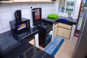 a small kitchen with a stove and a microwave at Alpha Homes in Mombasa