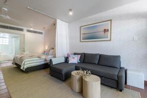 Studio on Macrossan في ميناء دوغلاس: غرفة معيشة بها أريكة وسرير