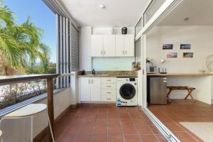 Studio on Macrossan في ميناء دوغلاس: مطبخ مع غسالة ملابس وشرفة