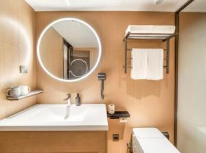 une salle de bains avec un lavabo et un miroir dans l'établissement JI Hotel Shanghai Pudong Airport Chuansha Road, à Shanghai 16 autres photos