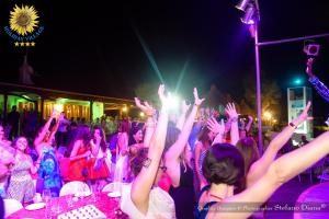 a group of people with their hands in the air at a party at Holiday Village in Fondi