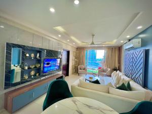 a living room with a couch and a tv at Elysium Tower Premium Serviced Apartments Facing Centaurus Mall Islamabad in Islamabad