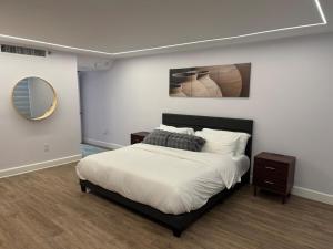 a bedroom with a large bed and a mirror at Beachfront two story apartment in Miami Beach
