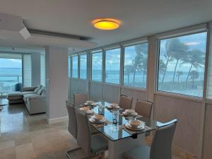 a dining room with a table and chairs with a view of the ocean at Beachfront two story apartment in Miami Beach