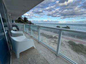 a balcony with chairs and a view of the ocean at Beachfront two story apartment in Miami Beach