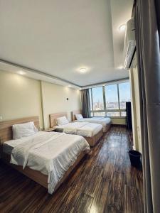 a hotel room with two beds and a large window at Good Nights Pyramids Hotel in Cairo +31 photos
