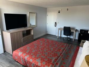 a hotel room with a bed and a flat screen tv at Roseville Inn in Roseville