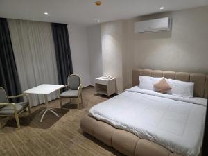 Gizapyramids heaven hotel- فندق جنة الاهرامات的一间卧室，里面有一张床、一张桌子和几把椅子。