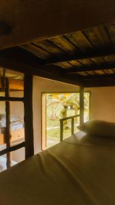 a bedroom with a view of a window and a bed at Drop House Hostel in Ubatuba