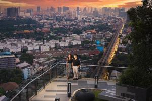 two people standing on the top of a building with a city at Oakwood Suites Tiwanon Bangkok in Nonthaburi