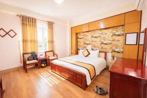 a hotel room with a bed and a desk at Hải Vân Hotel Điện Biên in Diện Biên Phủ