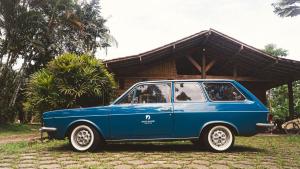 a blue car parked in front of a house at Drop House Hostel - Surf & Skate - Itamambuca in Ubatuba