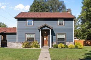 Stay at this Old Fashion House in Bardstown في باردستاون: منزل ازرق بسقف احمر