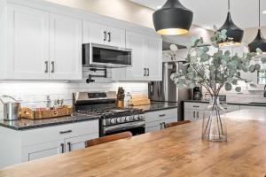 Stay at this Old Fashion House in Bardstown في باردستاون: مطبخ بخزائن بيضاء وطاولة خشبية +63 صورة