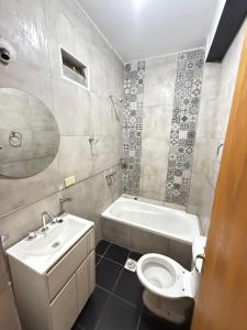 a bathroom with a toilet and a tub and a sink at Dulce Descanso in Salta