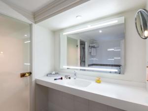 a bathroom with a sink and a mirror at Mercure Paris CDG Airport & Convention in Roissy-en-France