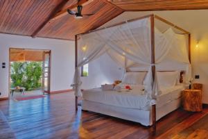 a bedroom with a bed with a canopy at Beach Villa l'Heure Bleue in Madirokely +43 photos