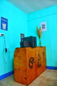 a wooden table with a tv on top of it at Ivan homestay in Kulu
